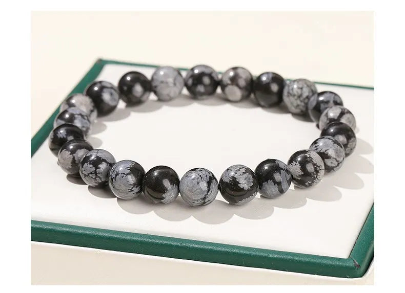 Närbild på GlowBreak™ snowflake armband – svart obsidian med snöflingeliknande mönster