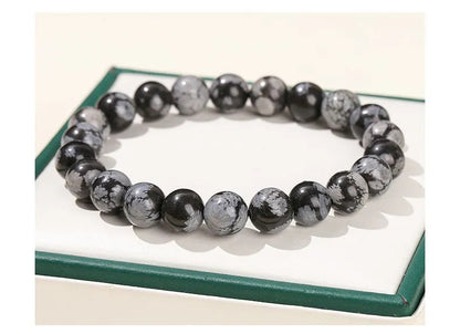 Närbild på GlowBreak™ snowflake armband – svart obsidian med snöflingeliknande mönster