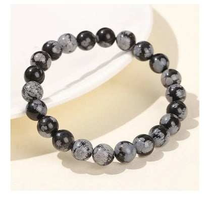 GlowBreak™ snowflake armband i feminin self-care miljö – elegant svart natursten från Flawless Glow